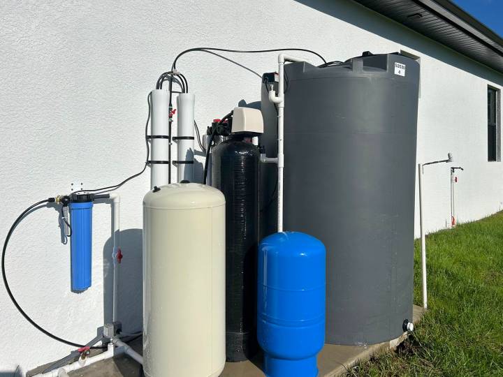 Complete reverse osmosis system along the side of a white home