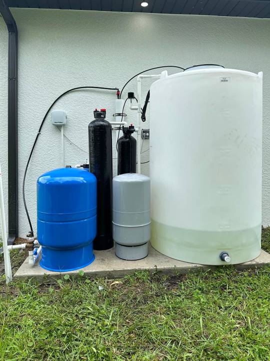 Blue and gray pressure tanks with a white storage tank
