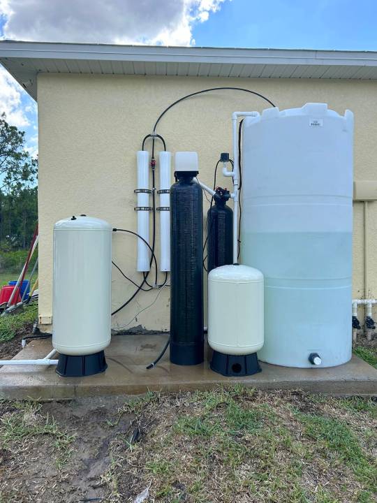 Whole-house reverse osmosis system beside a yellow home